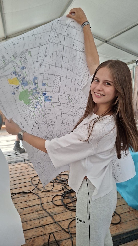 Maira mit einem Lageplan auf dem Veranstaltungsgelände