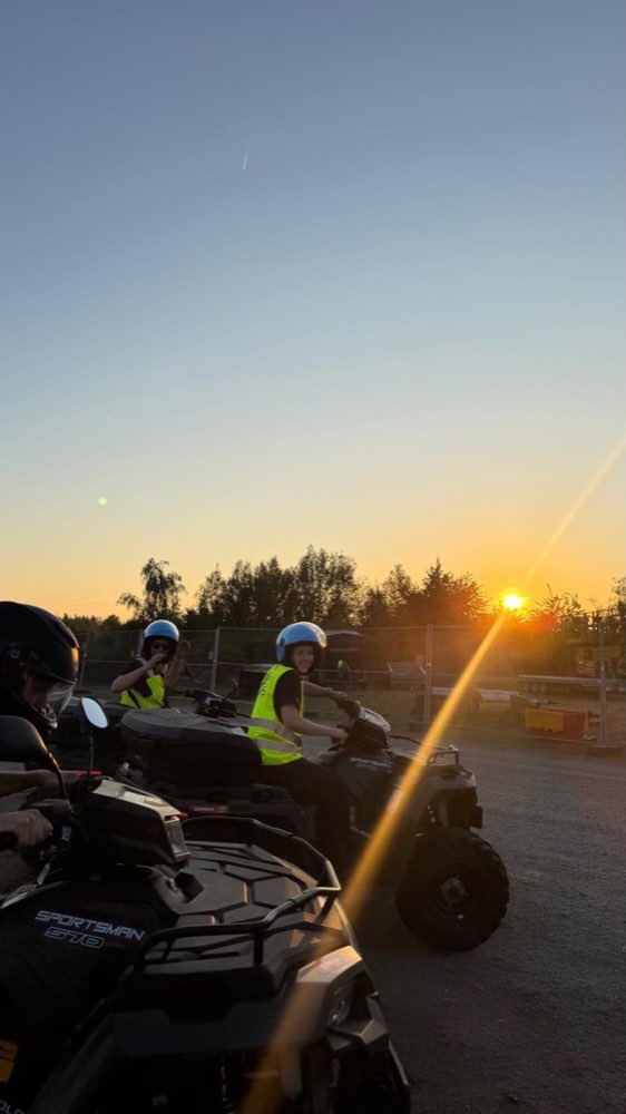 Teammitglieder mit Quads im abendlichen Veranstaltungsgelände