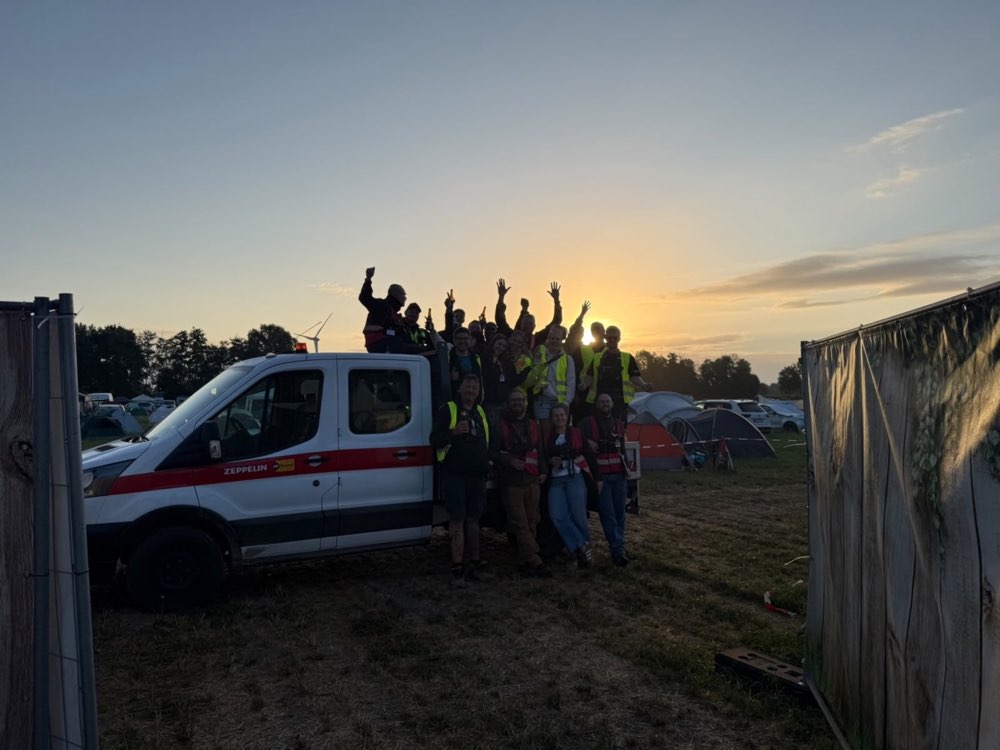 Eine Gruppe von Teammitgliedern jubelt im Abendlicht