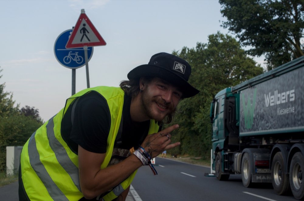 pluseins Teammitglied im Veranstaltungsgelände neben einem Produktionsfahrzeug